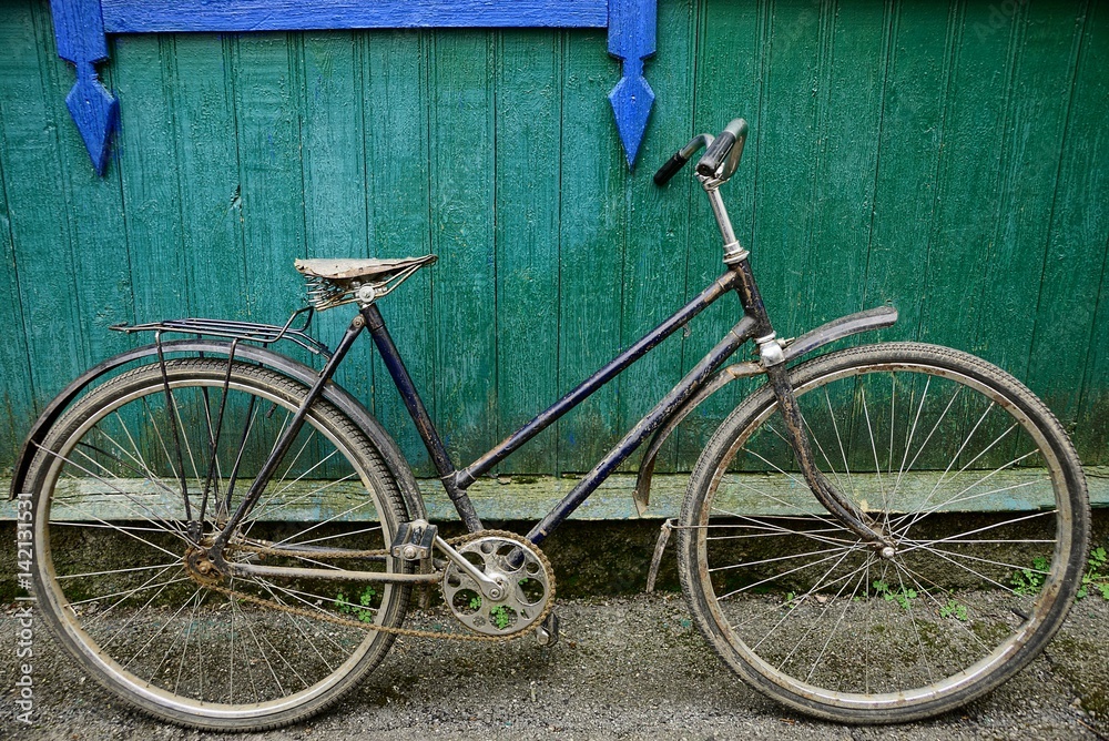 Старый,сельский велосипед возле деревянной зелёной стены