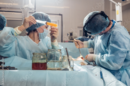 Surgeon taking scissors from the table photo