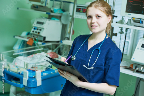 Female doctor portrait in front of intensive care unit for newborn infant baby photo