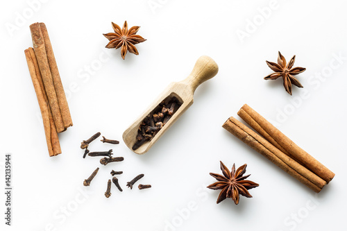 Cinnamon sticks with star anise, cloves and orange slices on white background