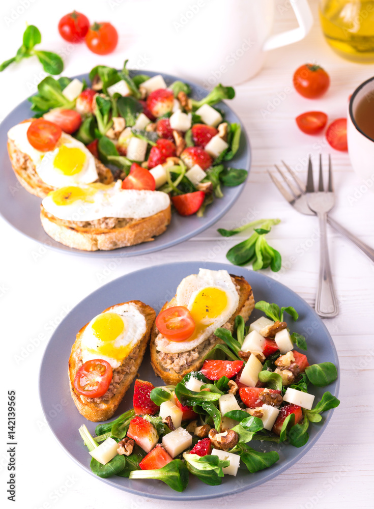 Salad with strawberry, spinach and goat cheese.  Bruschettes