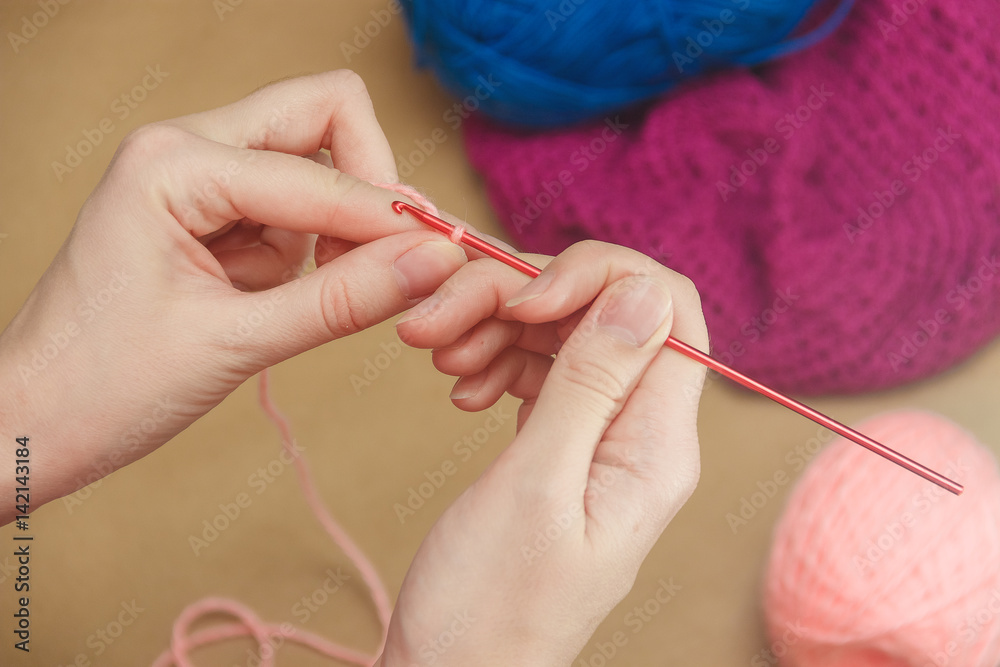 Close up of the hands of an young woman knitting.