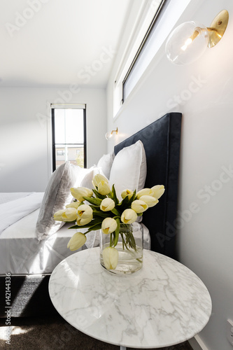 Yellow tulips on a bedside ...