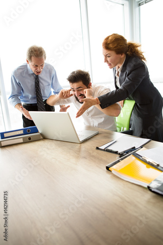 Mobbing, stress, work, scandal concepts. Angry bosses man and woman screaming at their executive worker, because they are not satisfied with his work.