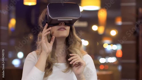 woman uses a virtual reality glasses on abstract background photo