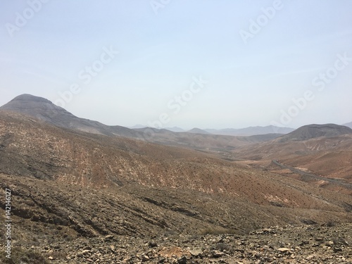 Mountains, valleys and dry land meet the blue sky