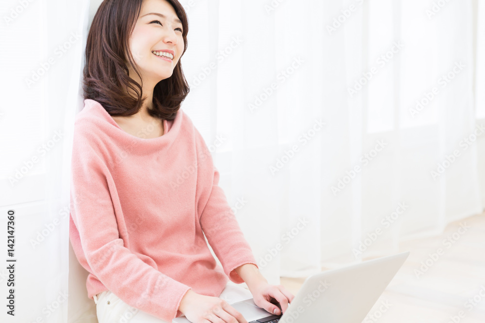 部屋でパソコンを見る女性 部屋でパソコンを見る女性