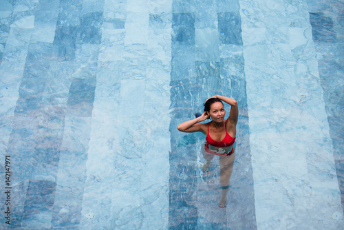Enjoying vacation. Smiling beautiful young woman in swimming pool. © romankosolapov