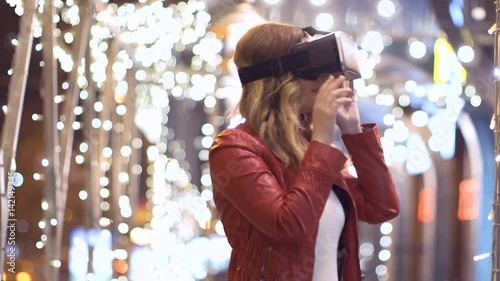 woman uses a virtual reality glasses on abstract background photo