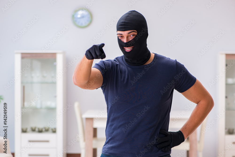 Robber wearing balaclava stealing valuable things Robber wearing balaclava stealing valuable things
