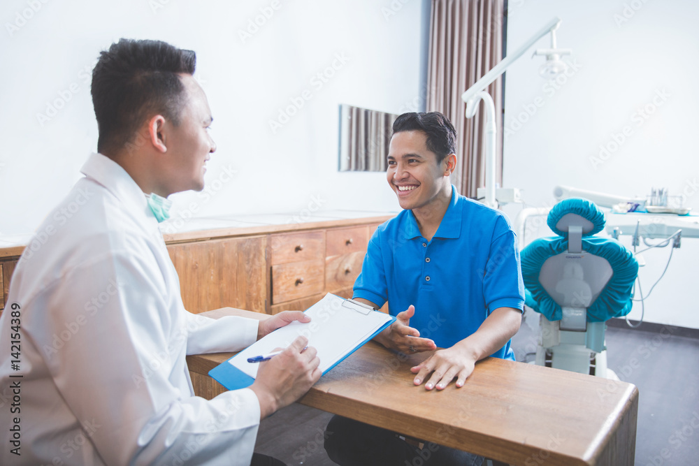 dentist talking to his patient at dental care clinic dentist talking to his patient at dental care clinic