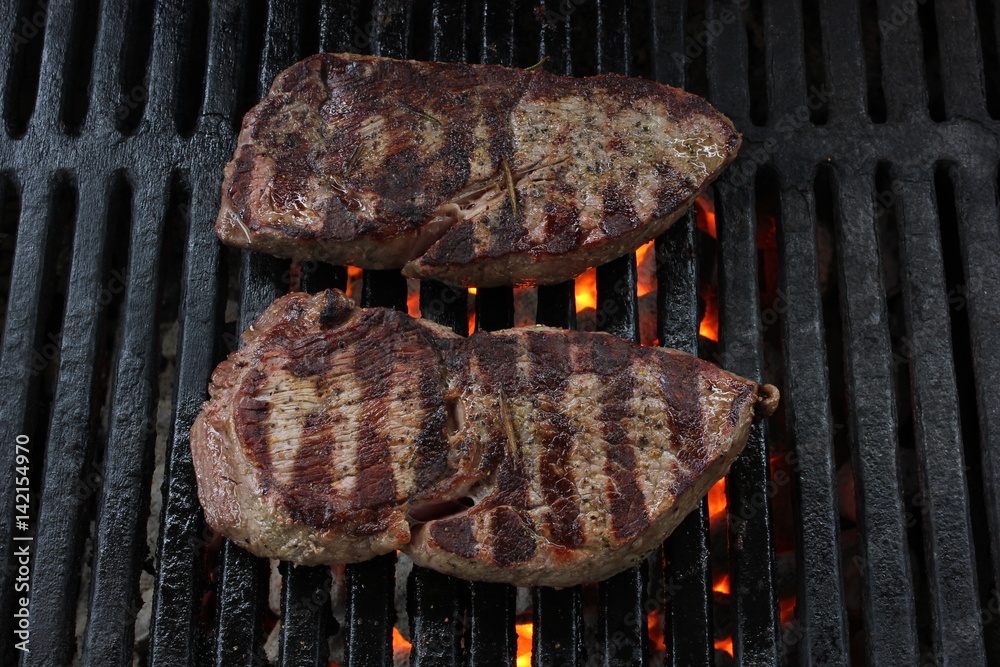 Two BBQ steaks on a charcoal grill with grill lines Stock Photo Adobe Stock