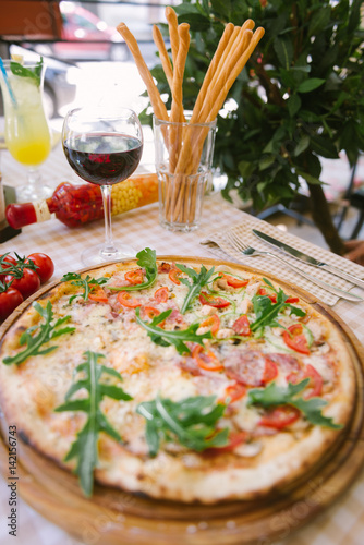 Pizza with glass of wine, on served table