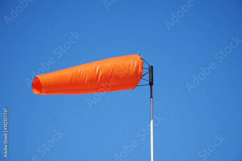 Bild auf Leinwand close up on orange windsock in the wind