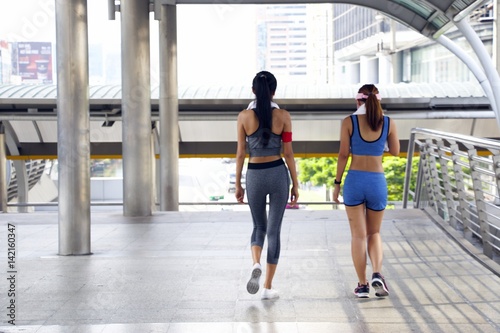 Sport women are walking together after jogging in the town