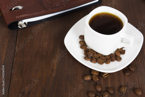 Business breakfast with coffee cup and notebook decorated with coffee beans