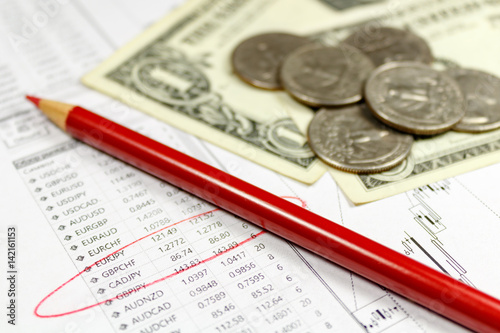 Coins with US dollars banknotes and red pencil on the background of table of exchange rates. Focus in the text © Vladimir Zhupanenko