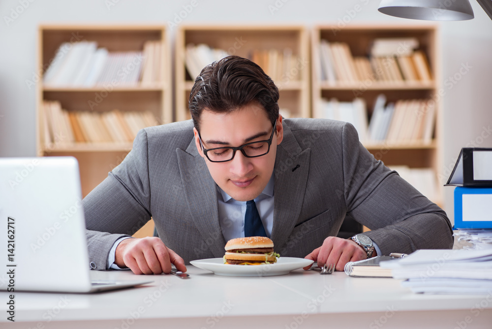 Hungry funny businessman eating junk food sandwich Hungry funny businessman eating junk food sandwich