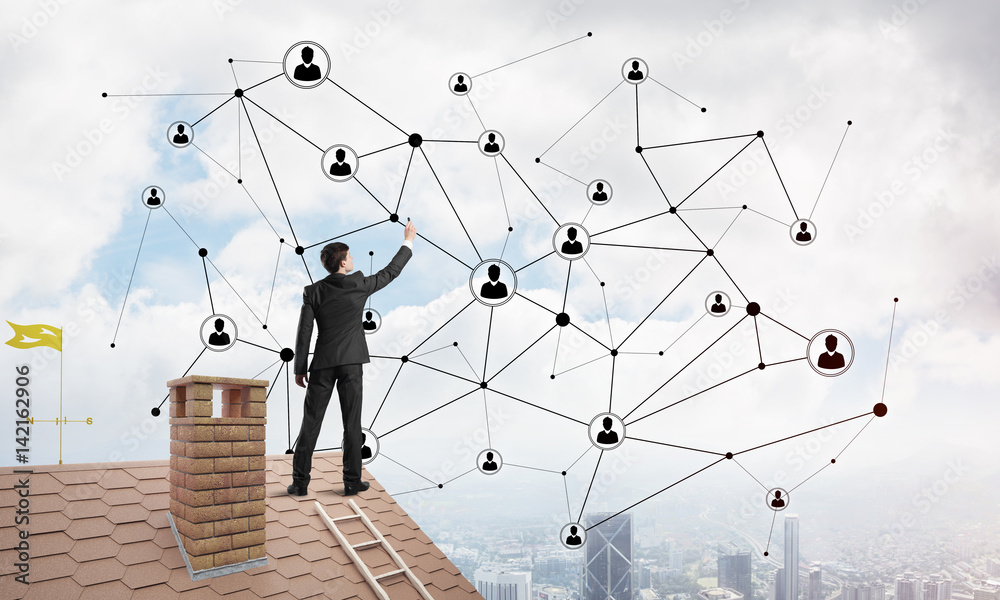Businessman on house roof presenting networking and connection concept. Mixed media Businessman on house roof presenting networking and connection concept. Mixed media
