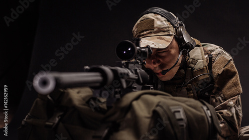 military contracto with his sniper rifle at night. war, army, weapon, technology and people concept photo