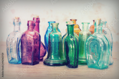 Coloured glass bottles on a rustic background