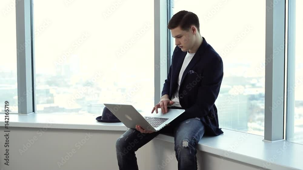 Five Minutes Before the Presentation of My Project/Young businessman is checking his presentation before the meeting. He’s very focused. He is in the office with large bright windows