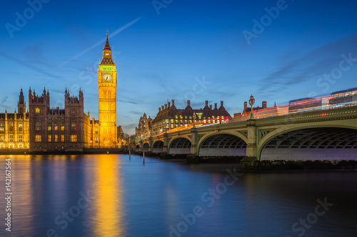 London  England - The Big Ben Clock Tower and Houses of Parliament with iconic red double-decker buses at city of westminster by night