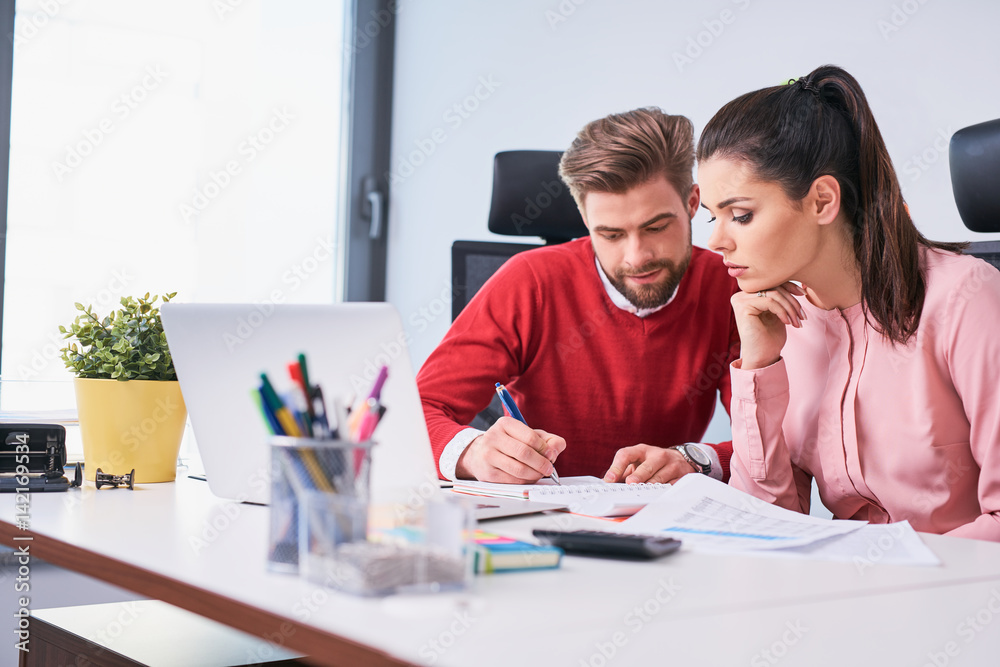 Young man teaching coworker during business training at office Young man teaching coworker during business training at office