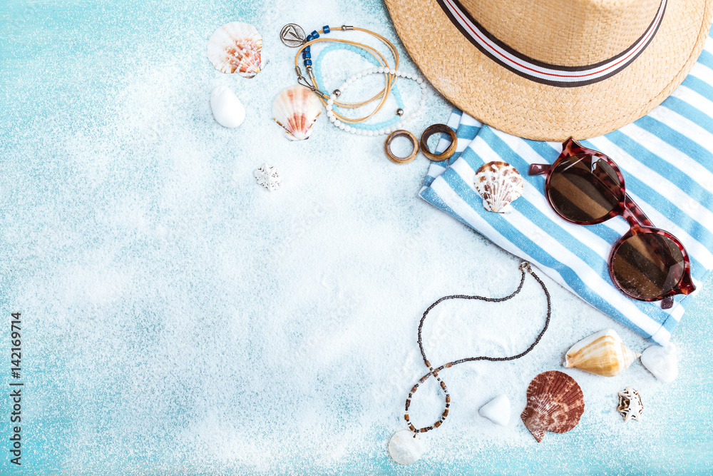 top view of straw hat, sunglasses and striped clothes on blue tabletop with white sand. Summer holidays concept - obrazy, fototapety, plakaty 