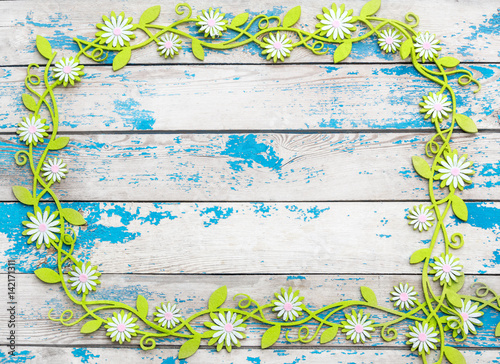 Frame of decorative flowers on the old wooden background.