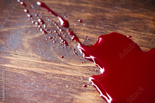 A puddle of blood on a wooden background