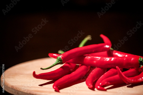 Red hot chilly peppers on a wooden board. photo