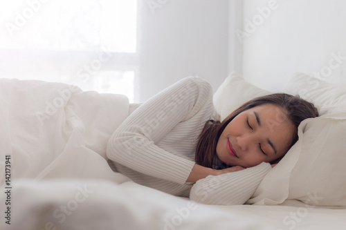 Happy young beauty women sleeping and smile on bed in the morning