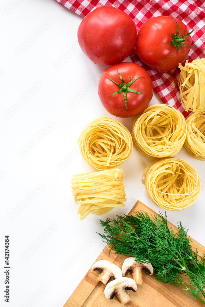 An upper view on an Italian food ingredients isolated in white. Pasta, tomatoes, greens, mushrooms. Top view with copy space. An upper view on an Italian food ingredients isolated in white. Pasta, tomatoes, greens, mushrooms. Top view with copy space.