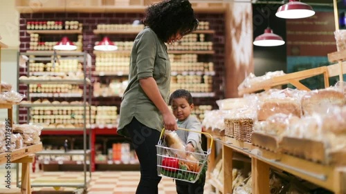 Mother and son buying bread in grocery store