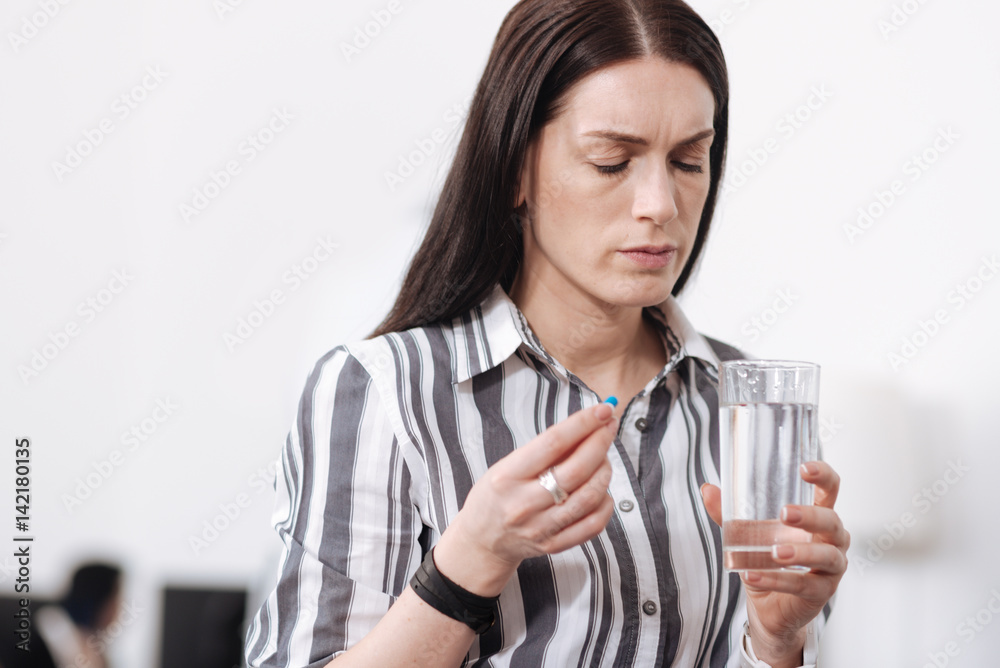 Thoughtful female looking at glass with water Thoughtful female looking at glass with water