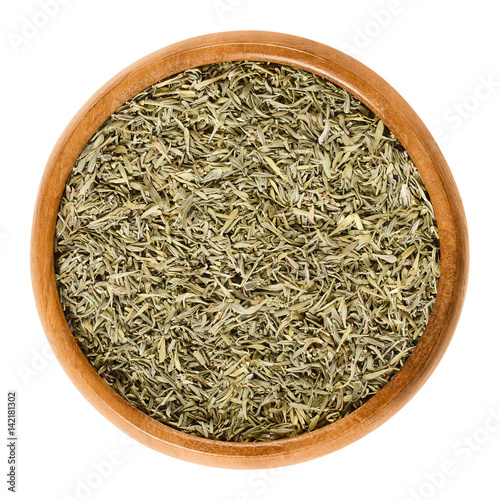 Fresh thyme stems in wooden bowl. Green herb with culinary, medicinal and ornamental uses. Thymus vulgaris is a relative of oregano. Isolated macro food photo close up from above on white background.