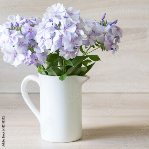 Wallpaper Mural Bouquet of blue phlox in a white vase  on wooden background. Torontodigital.ca