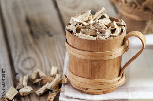 Marshmallow root (Althaea officinalis) in wooden cup. Copy space