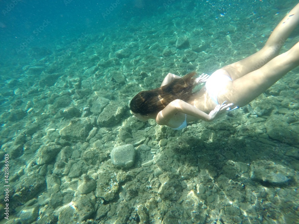 Chica buceando en mar de agua cristalina