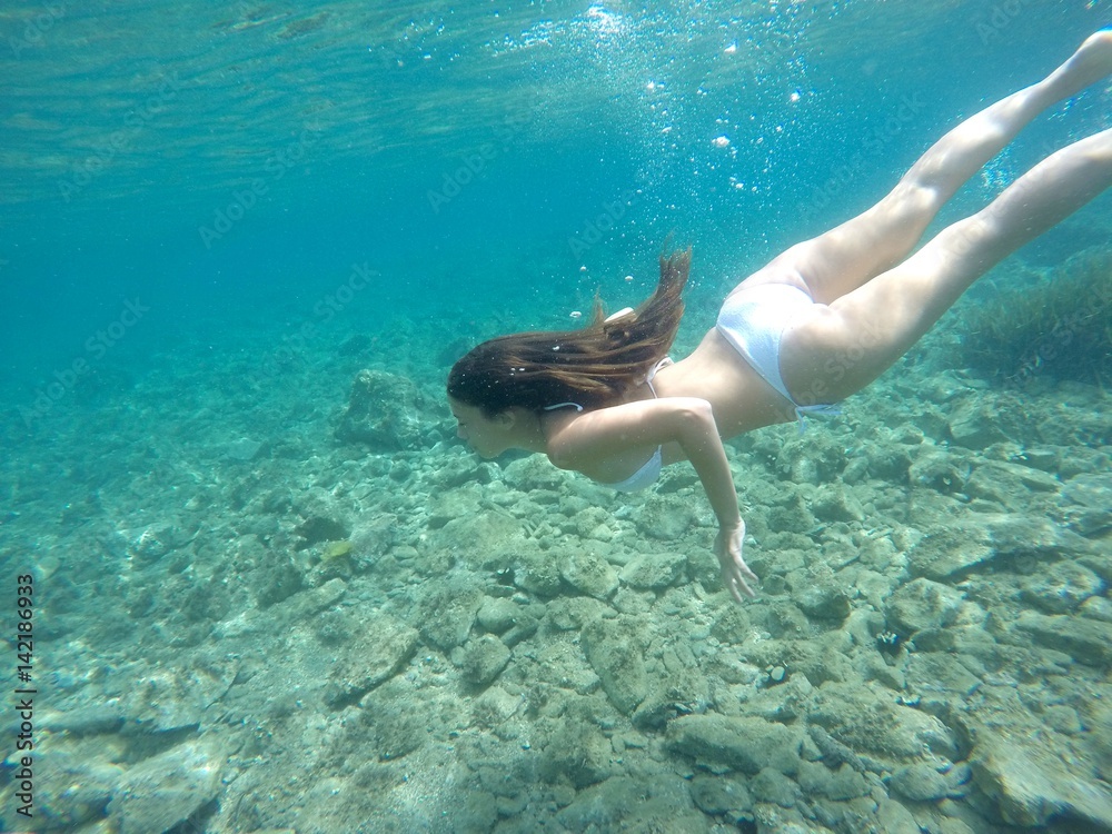 Chica buceando en mar de agua cristalina