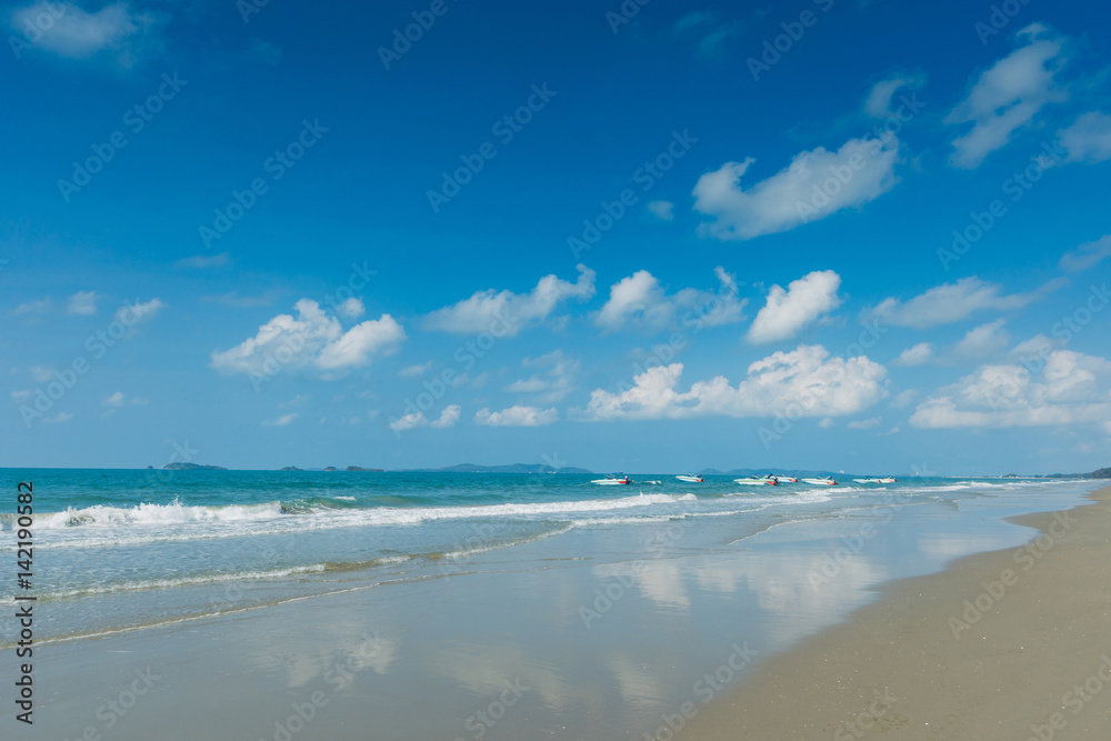 Tropical beach with clear water , blue sky and speed boats