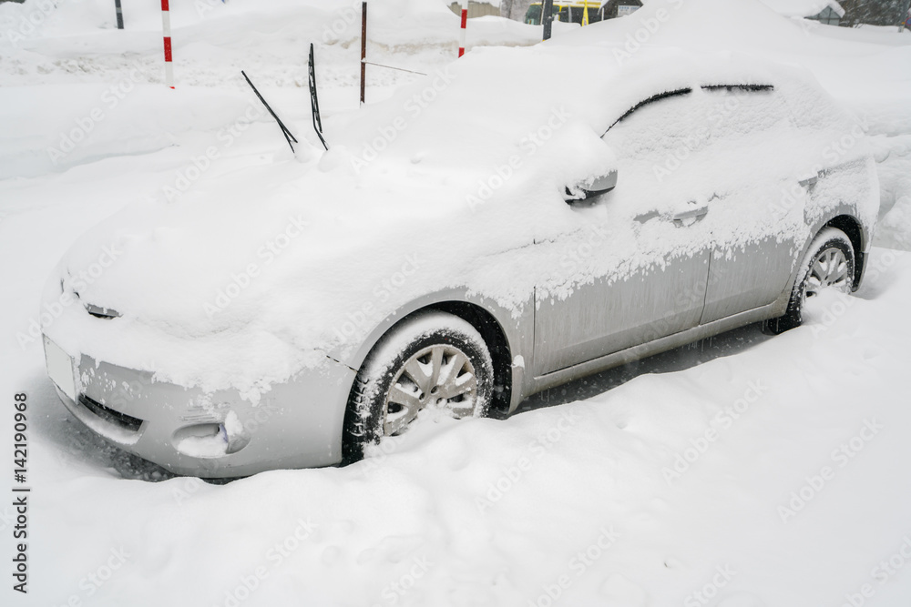 Cars covered with white snow in winter .