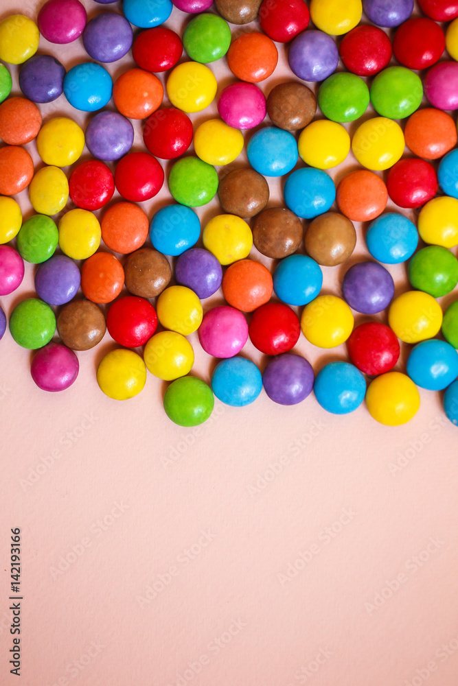 Multi-colored candies on pink background Multi-colored candies on pink background