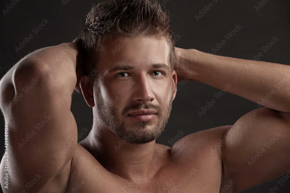 Model man with an open chested on a dark background , muscular body of a young man in jeans . Shot in a studio . Model man with an open chested on a dark background , muscular body of a young man in jeans . Shot in a studio .