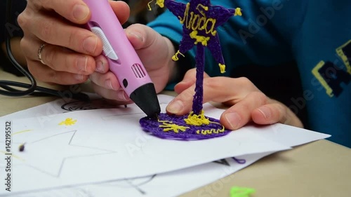 Woman teaches child to use a 3D pen
