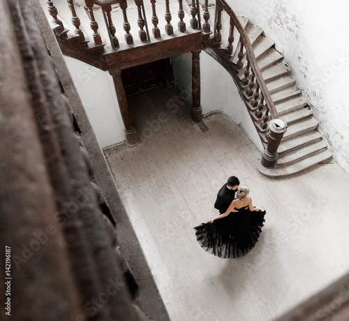 Portrait of a young couple dancing in black suit and dress. Wedding