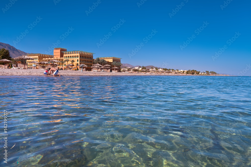 Wakacje w Egipcie. Plaża na wybrzeżu morza czerwonego przy ekskluzywnym hotelu.