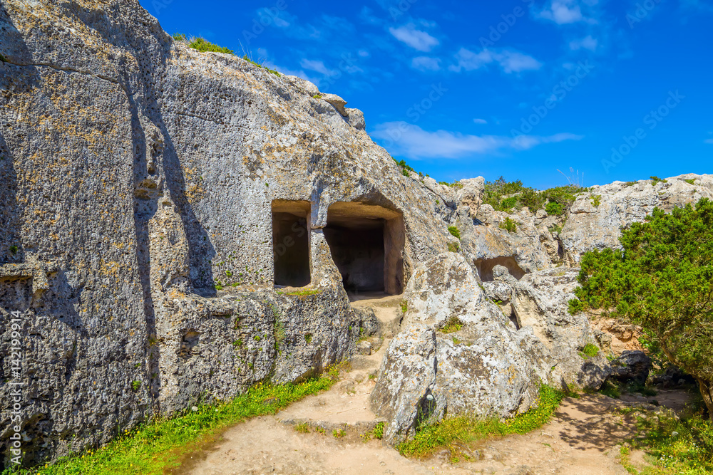 Cala Morell ancient caves on summer sunny day at Menorca island.