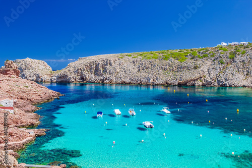 Murais de parede Cala Morell cove with its red rocks and crystal clear blue water
